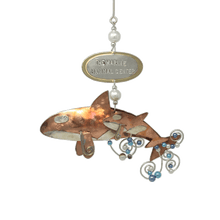 Load image into Gallery viewer, Copper and silver-colored metal orca and baby ornament with blue and white beads. Oval metal hangtag on hanger reads "THE MARINE MAMMAL CENTER".