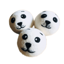 Load image into Gallery viewer, 3 white wool dryer balls with seal faces felted on in black.