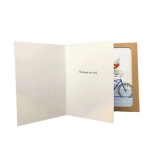 Load image into Gallery viewer, Open holiday card with inside greeting: "Wishing you joy!" placed in front of a brown box of polar bear holiday cards.