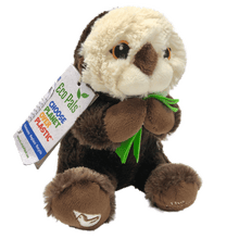 Load image into Gallery viewer, Plush brown and light tan sea otter with embroidered eyes holding bright green kelp. Embroidered feet show white The Marine Mammal Center name and logo in white thread. Paper tag reads "Eco Pals - Choose planet over plastic".