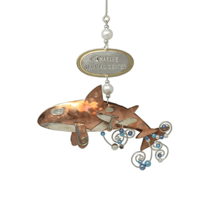 Copper and silver-colored metal orca and baby ornament with blue and white beads. Oval metal hangtag on hanger reads "THE MARINE MAMMAL CENTER".