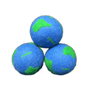 Three blue dryer balls with green patches, resembling Planet Earth. 