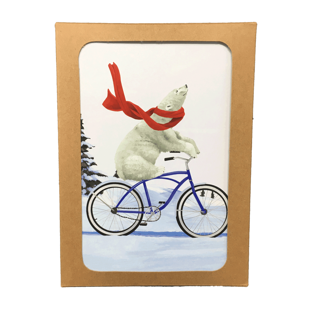 Brown box containing holiday cards with polar bear wearing a red scarf, riding a bike through a snowy landscape.
