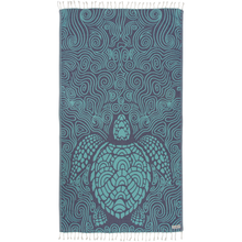 Load image into Gallery viewer, Indigo towel featuring mint-green block-print style sea turtle surrounded by swirl designs. White tassel fringe along top and bottom.
