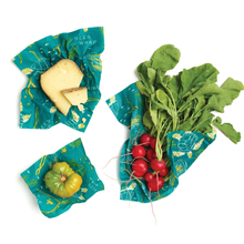 Load image into Gallery viewer, 3 ocean-patterned beeswax wraps containing cheese, a bell pepper, and red radishes.
