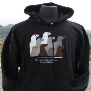 Black hooded sweatshirt featuring design with 10 sea lion profiles in white, gray, tan, and brown on front. Text "The Marine Mammal Center Sausalito, California" beneath image.