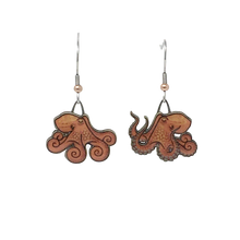 Load image into Gallery viewer, Orange earrings in shape of octopuses; octopus on right has three arms up, displaying suction cups. Copper bead at base of each ear wire.
