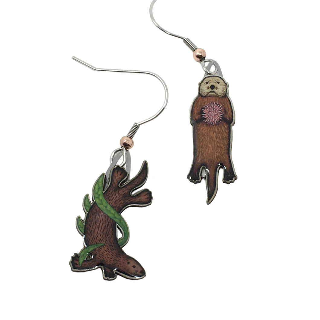 Mismatched earrings in shape of sea otters; left: otter diving in green kelp, right: swimming otter with purple sea urchin on chest. Copper bead at base of each ear wire.