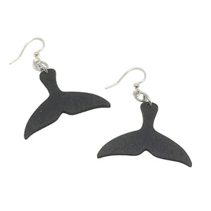 Two black wooden earrings in the shape of a whale fluke/tail linked to silver earring hooks.