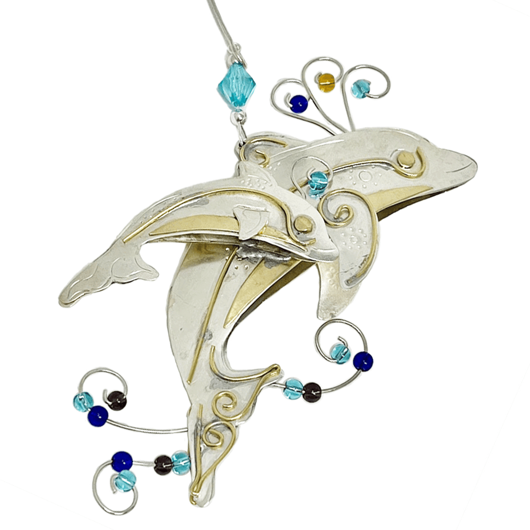 Silver and tan-colored metal ornament in shape of mom and baby dolphin, with blue and brown beads.