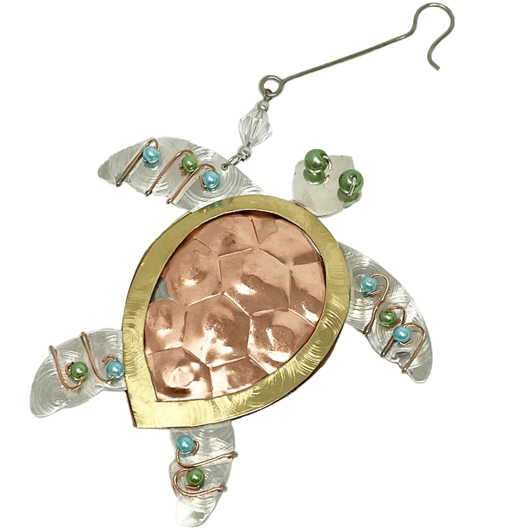Silver and copper-colored metal ornament in shape of sea turtle, with blue, green, and white beads.