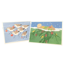 Load image into Gallery viewer, 2 holiday cards: sandpipers holding red baubles, and sea otter floating on its back holding kelp and red and yellow stars.
