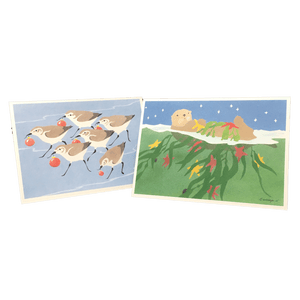 2 holiday cards: sandpipers holding red baubles, and sea otter floating on its back holding kelp and red and yellow stars.