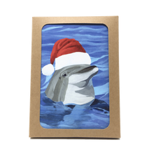Load image into Gallery viewer, Box of holiday cards with dolphin wearing Santa hat on cover.
