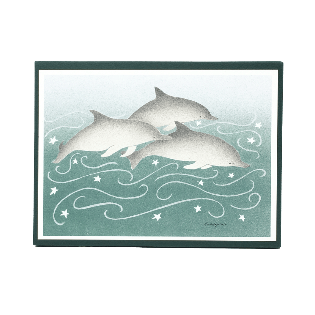 Box of holiday cards with 3 dolphins against green-blue background on cover.