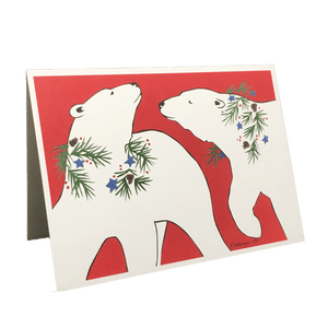 Red holiday card with 2 polar bears wearing wreaths of pine needles, pinecones, blue stars, and red berries.