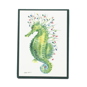 Holiday card box cover with green seahorse carrying a string of multi-colored holiday lights.