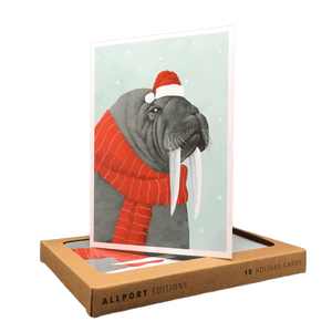Holiday card with walrus wearing Santa hat and red striped scarf.