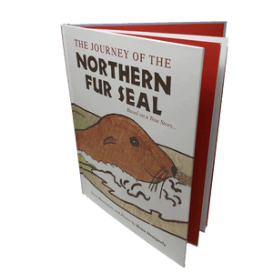 "The Journey of the Northern Fur Seal" slightly open, exposing the red and white pages within.