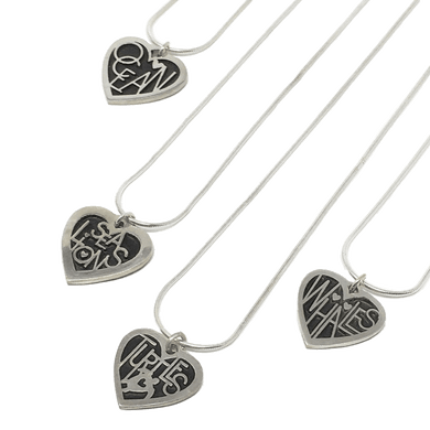 4 silver heart necklaces reading Ocean, Sea Lions, Turtles, and Whales on their pendants from left to right.