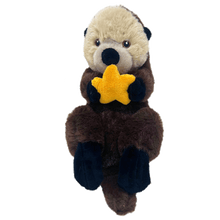 Load image into Gallery viewer, Sea otter plush with embroidered eyes, light brown and dark brown fur, black paws, holding and orange seastar.
