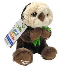 Load image into Gallery viewer, Plush brown and light tan sea otter with embroidered eyes holding bright green kelp.  Embroidered feet show white The Marine Mammal Center name and logo in white thread.  Paper tag reads &quot;Eco Pals - Choose planet over plastic&quot;.
