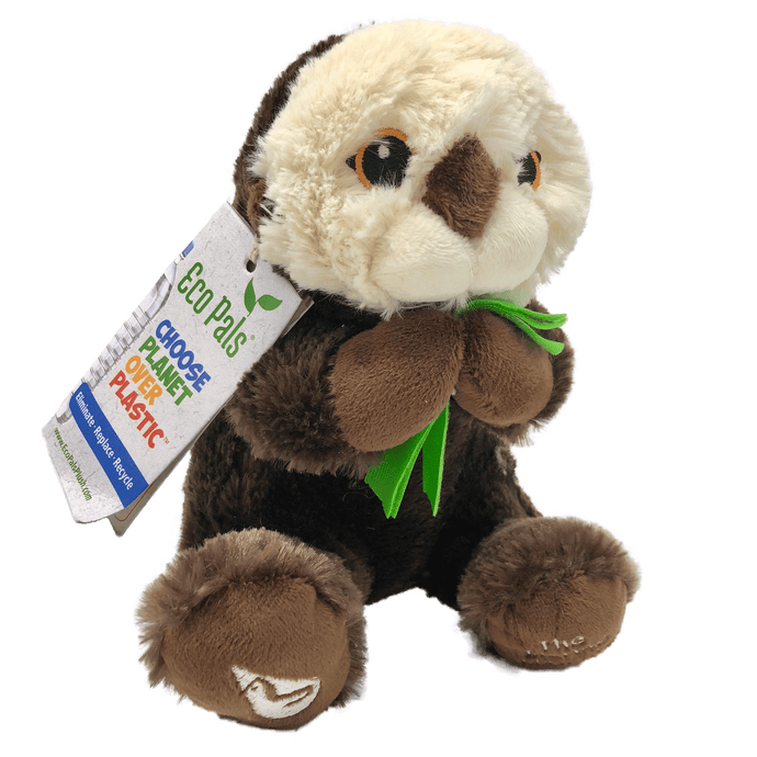 Plush brown and light tan sea otter with embroidered eyes holding bright green kelp.  Embroidered feet show white The Marine Mammal Center name and logo in white thread.  Paper tag reads 