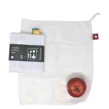 Load image into Gallery viewer, A mesh white reusable produce bag with a red tag lays flat on a surface, a 5-pack of white reusable mesh bags sits folded in black packaging with white lettering on top. A red apple sits on the laid out bag in the bottom right corner.
