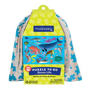 Tan drawstring bag with blue puzzle pattern and ocean animals puzzle image on cardboard outer packaging. 