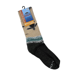 Pair of crew-length socks with design of baby sea turtles entering the ocean from the beach. Tan upper half and forest-green lower half.  Packaging says "Cotton Crew Sock - Socksmith Outlands, Made in the USA - Recycled Yarns"