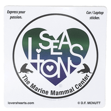 Load image into Gallery viewer, Circular sticker with blue and green heart design containing white letters &quot;SEA LIONS&quot; and &quot;The Marine Mammal Center&quot; in black text below. Heart is flanked by 2 sea lion silhouettes.
