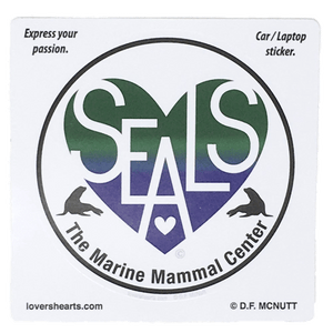 Circular sticker with blue and green heart design containing white letters "SEALS" and "The Marine Mammal Center" in black text below. Heart is flanked by 2 seal silhouettes.
