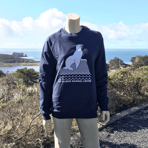 Navy blue sweatshirt on a mannequin overlooking a coastal backdrop. 