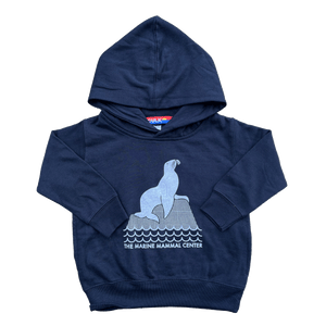 Toddler hooded sweatshirt in navy with an image of a sea lion on a rock and the words "The Marine Mammal Center".