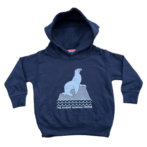 Toddler hooded sweatshirt in navy with an image of a sea lion on a rock and the words "The Marine Mammal Center".