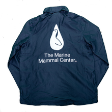 Load image into Gallery viewer, Back of navy blue windbreaker with The Marine Mammal Center&#39;s logo in white, centered and extra-large
